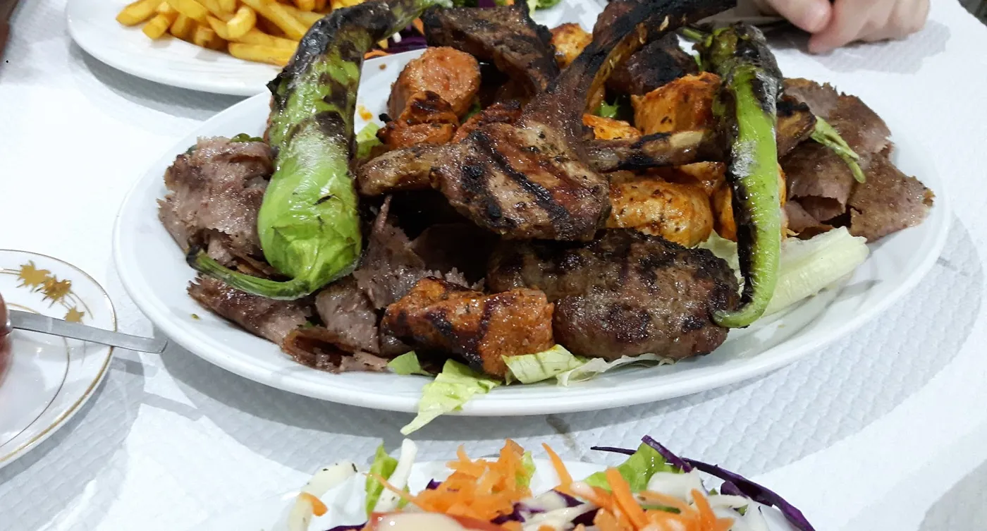 Grand plateau de grillades avec piments, frites et thé