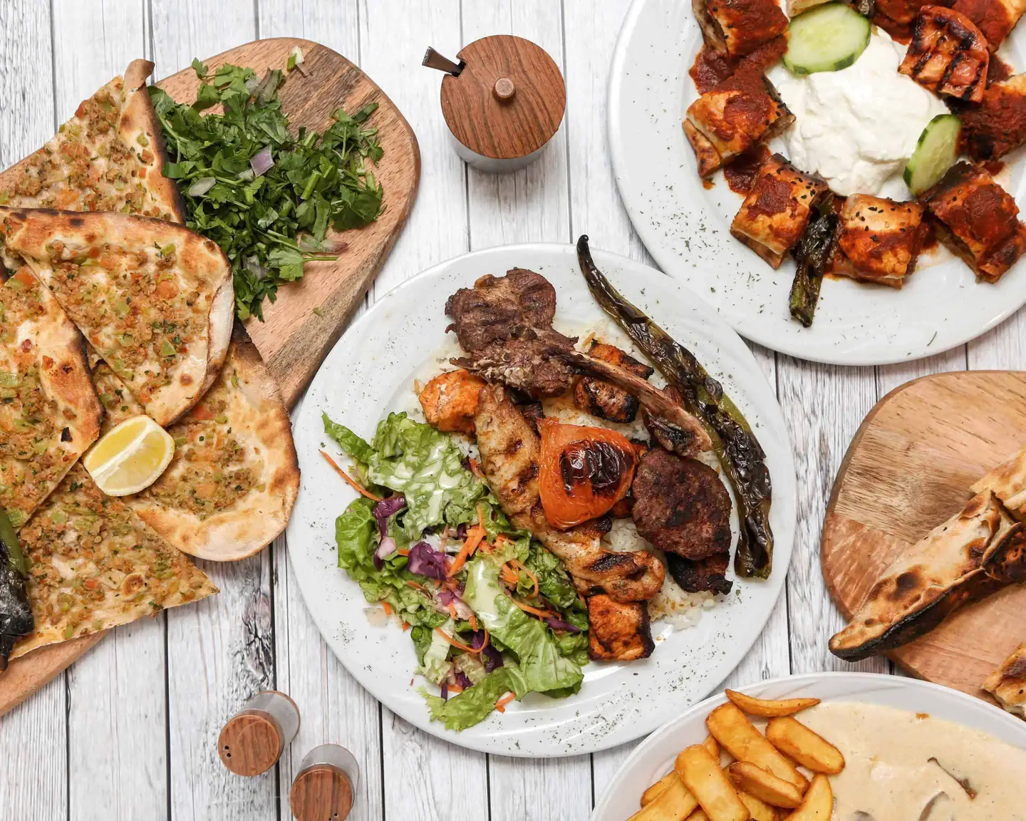 Grillade mixte, pides, iskender et escalope à la crème sur une table en bois